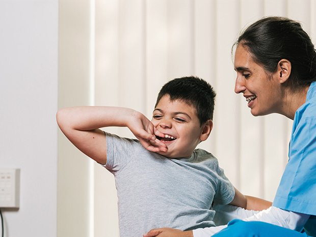 smiling boy with caregiver in medical setting laughter and joy education connection